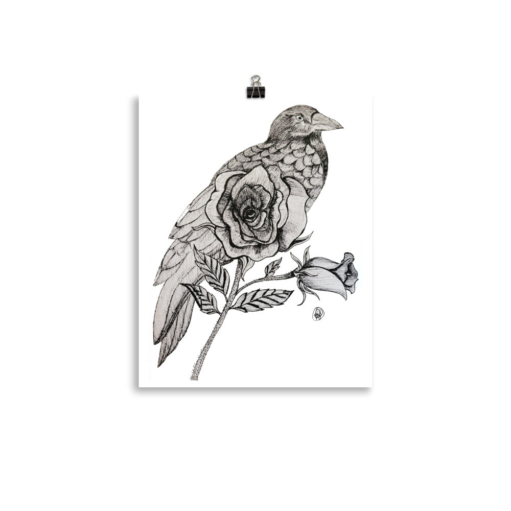 A vertical art print featuring a detailed black and white illustration of a raven perched on a rose branch, shown hanging from a small black binder clip against a white background.