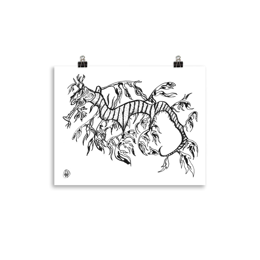 A black and white art print depicting a stylized, hand-drawn sea creature or kelp-like marine illustration, shown hanging from two black binder clips against a solid white background.