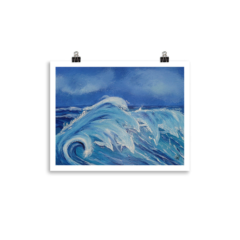 An art print depicting a powerful blue ocean wave, shown hanging from two black binder clips against a solid white background.